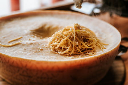 Delicious spaghetti pasta preparation. Spaghetti pasta in a parmesan cheese wheel.の写真素材