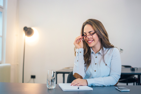 Attractive young woman with glasses in office.の写真素材