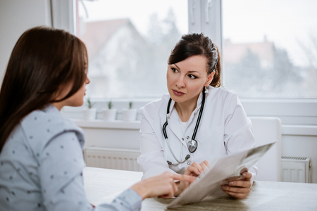 Beautiful female doctor explaining test results to a patient. の写真素材