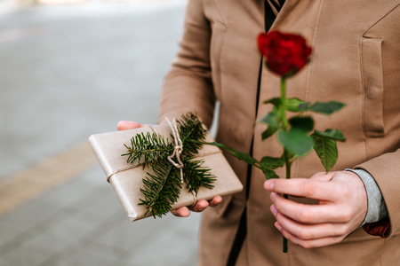 Close up of man giving a rose and a present. Valentine's day.の写真素材