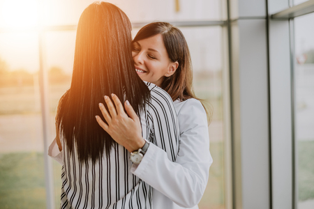 Caring young medical doctor hugging patient.の写真素材