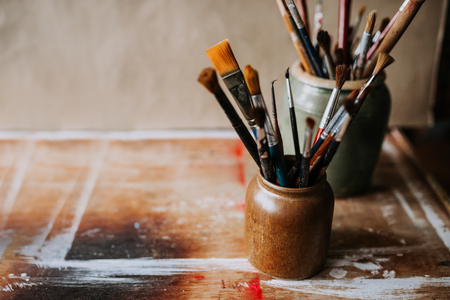 Artistic image of paint brushes in a ceramic jar.の写真素材