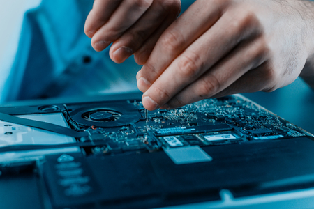 Close-up of male hands repairing laptop. Hardware.の写真素材