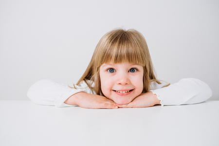 Portrait of a beautiful little girl looking at camera. Isolated background.の写真素材