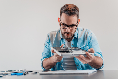 Handsome serious computer engineer repairing  hardwareの写真素材