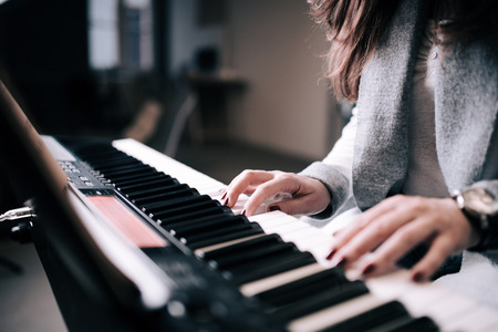 Close-up image of unrecognizable female person playing piano.の写真素材