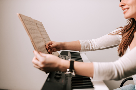 Close-up image of female pianist holding sheet music. Preparing before playing.の写真素材