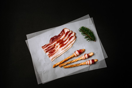 Bacon slices. Pretzels with bacon. Black background.の写真素材