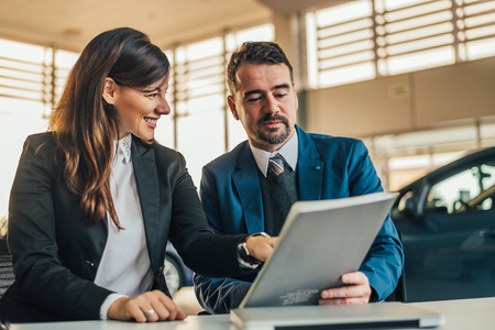 Car dealer showing contract to his client.の写真素材
