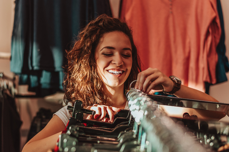 Young happy girl in a shop buying clothes.の写真素材