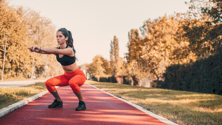 Sporty woman doing squats in park.の写真素材
