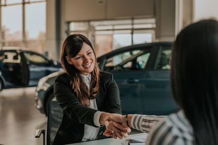 Beautiful saleswoman shaking hands with customer.の写真素材