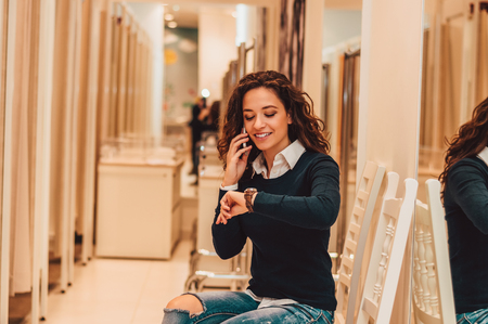 Woman in dressing room talking on phone.の写真素材