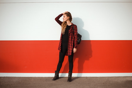 Young fashionable woman posing outside on bright day.