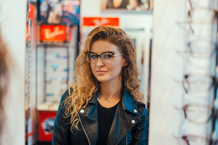 Girl trying on glasses with black rims.のeditorial素材