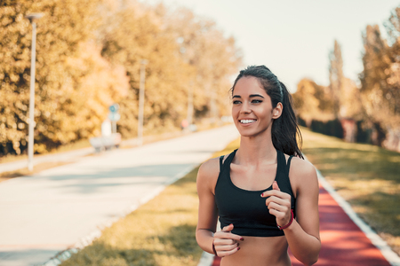 Young woman jogging in morning looking over shoulder.