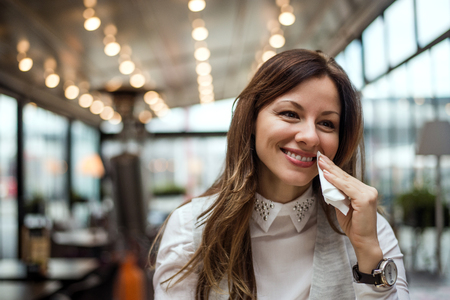 Beautiful young woman in the restaurant, wipes mouth with a napkin.の写真素材