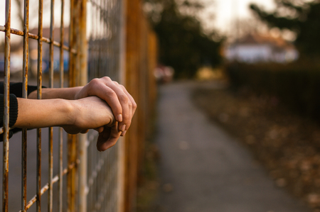 Prisoner's arms resting in prison jail yardの写真素材