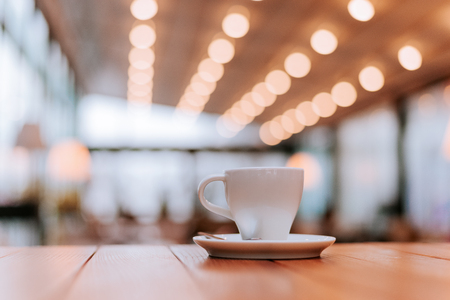 Coffee shop interior, coffee cup on wooden table.の写真素材