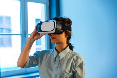 Happy woman getting experience using VR-headset glasses of virtual realityの写真素材