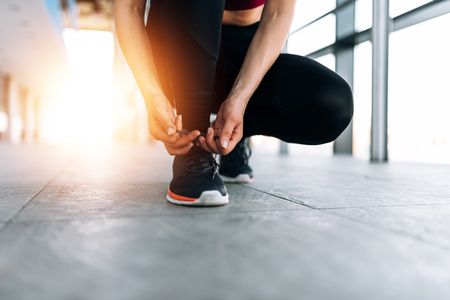 Sport lifestyle. Close-up of female runner tying shoelace.の写真素材
