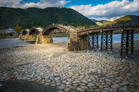 IWAKUNI, JAPAN - November 26, 2015 : Visitors are walking on Kintai Bridge spanning the Nishiki River in Iwakuni.The 17th century wooden arch bridge is a popular attraction, giving access to Iwakuni Castle.のeditorial素材