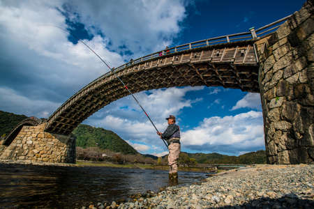 IWAKUNI, JAPAN - November 26, 2015 : A unidentified fisherman is fishing in the Nishiki River, under...