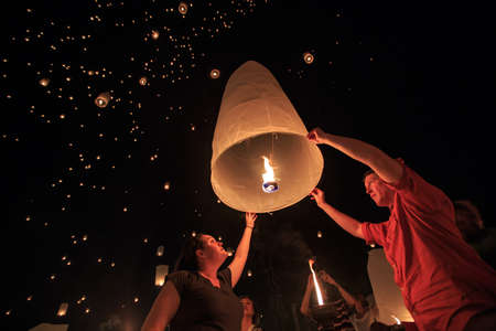 CHIANG MAI, THAILAND - NOVEMBER 8, 2014 : Group of visitors launch a sky lantern on the night of the annual festival known as Yee Peng (Yi Peng).のeditorial素材