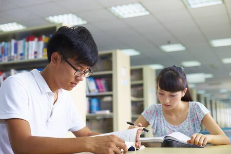 Young asian or Chinese college students study together in the libraryの写真素材