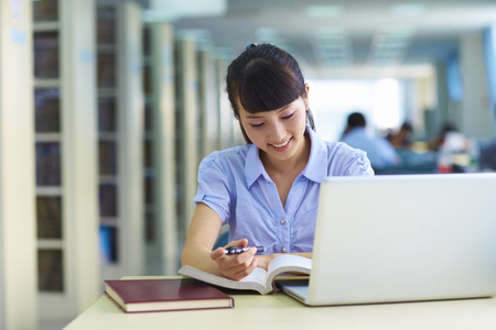 one pretty young Asian or Chinese college student study in the libraryの写真素材