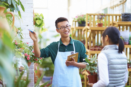 Young Asian Male Florist Have Conversation with his Customer in the Shopの写真素材