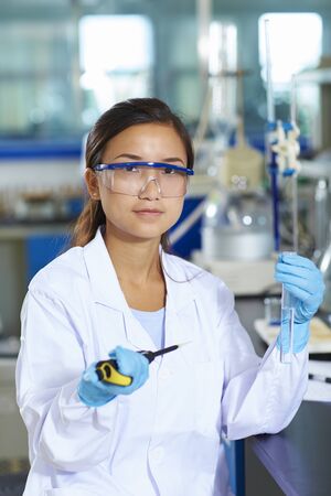 One Female Chinese Laboratory scientist working at lab with test tubes