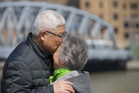 Happy Senior Chinese tourist couple taking pictures at Garden Bridge of Shanghaiの写真素材