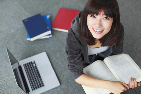 female college student using laptop in librayの写真素材