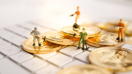 Bitcoin with little figure on keyboardの写真素材