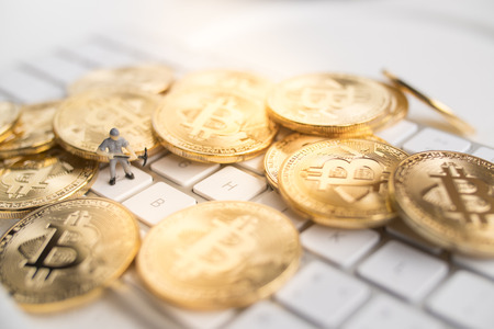 Bitcoin with little figure on keyboardの写真素材