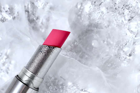 Pink red lipstick in silver tube on ice background, copy spaceの写真素材