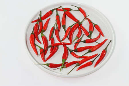 Bunch of raw fresh red chili pepper on white