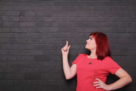 Young woman showing finger up, copy space