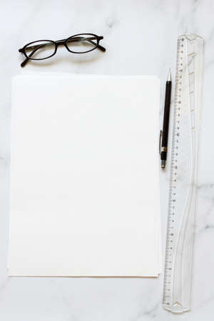 A4 format blank paper with glasses and pen on marble table