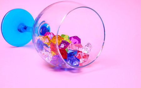 Multicilired gems in wine glass on colorfull background