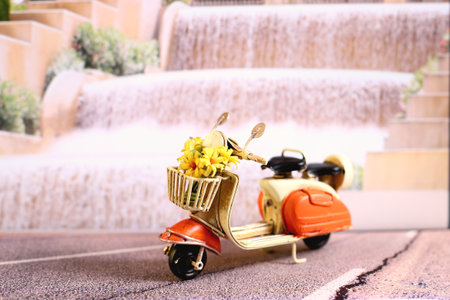 Retro scooter with yellow flowers bouquet on the streetの写真素材