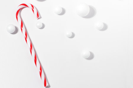 New Year Christmas card with red candy cane on white background with hard lightの写真素材