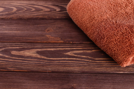 Brown soft bath towel, wooden table, copy spaceの写真素材