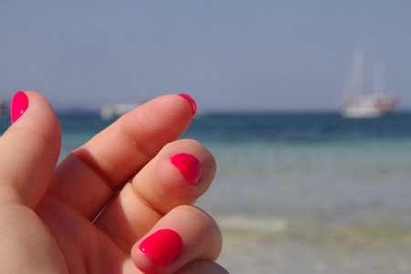 Pink nails manicure, summer style, sea backgroundの写真素材