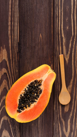 Empty wooden spoon mockup and raw papaya fruitの写真素材