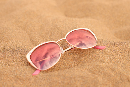 Sunglasses on beach sand, summer vacation accessory