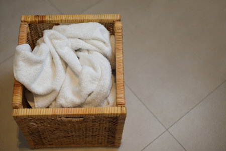 Dirty laundry in wooden box, towels in bathroomの写真素材