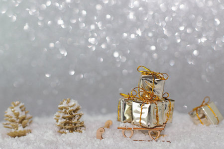 Shiny wrapped giftboxes on sladge in snow, Christmas cardの写真素材