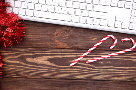 Laptop computer keyboard and Christmas and New Year decoration on brown wooden desktopの写真素材
